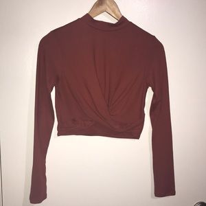 Long sleeve turtle neck crop top. Crossed by belly